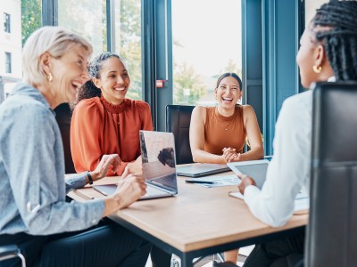 Mitarbeiterinnen im Büro mit Laptop an einem Besprechungstisch