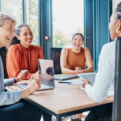 Mitarbeiterinnen im Büro mit Laptop an einem Besprechungstisch