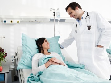 Krankenhauszusatzversicherung: Frau beim Arztgespräch im Einbettzimmer
