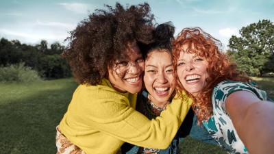 Zahnzusatzversicherung - Testsieger : Drei Jugendliche beim Selfie im Park