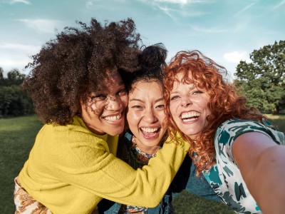 Zahnzusatzversicherung - Testsieger : Drei Jugendliche beim Selfie im Park