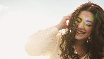 Eine Frau mit Zahnspange telefoniert und lacht dabei