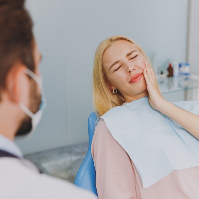 Frau mit Zahnschmerzen beim Zahnarzt