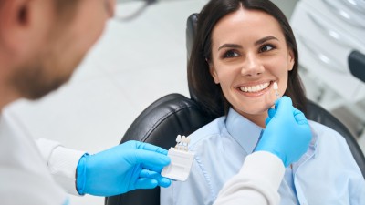 Zahnarzt gleicht Veneers an einer Patientin ab