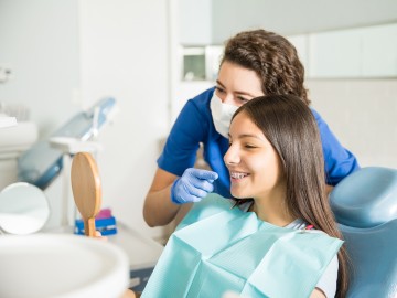 Zahnärztin erklärt einer Patientin die Zahnspange