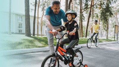 Vater bringt seinem Kind das Fahrradfahren bei