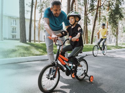 Vater bringt seinem Kind das Fahrradfahren bei