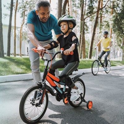 Vater bringt seinem Kind das Fahrradfahren bei