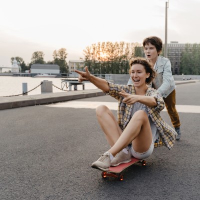 Unfallversicherung kündigen: Zwei Frauen mit einem Skateboard