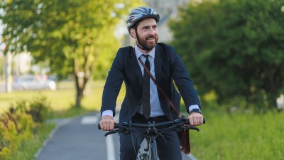 Mann mit Anzug auf dem Fahrrad unterwegs