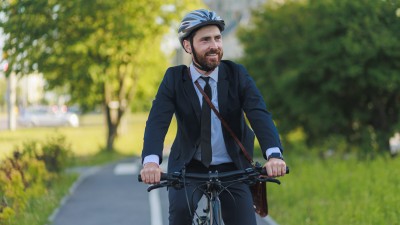Mann mit Anzug auf dem Fahrrad unterwegs