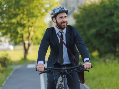 Mann mit Anzug auf dem Fahrrad unterwegs