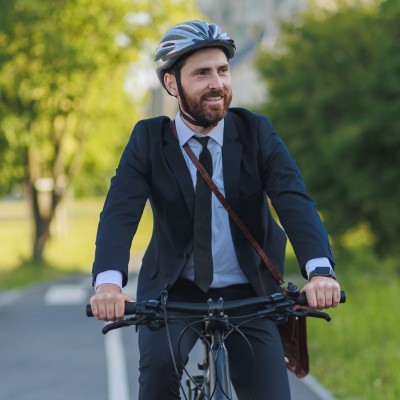 Mann mit Anzug auf dem Fahrrad unterwegs