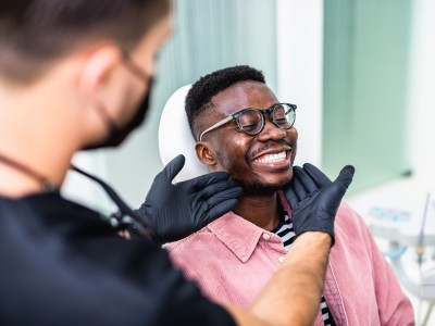 Patient lächelnd auf dem Behandlungsstuhl einer Zahnarztpraxis 