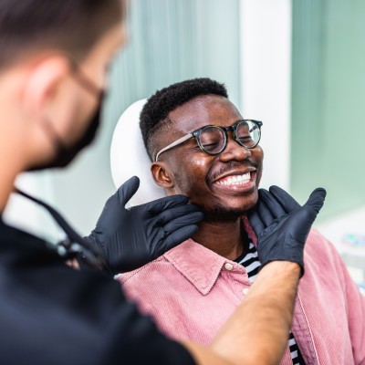 Patient lächelnd auf dem Behandlungsstuhl einer Zahnarztpraxis 