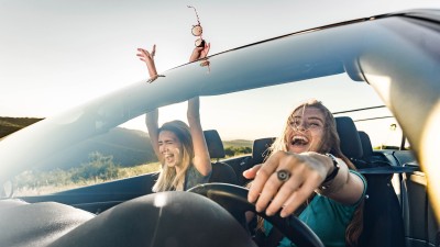 Zusatzfahrer-Versicherung: Zwei Frau im Cabrio entspannt unterwegs
