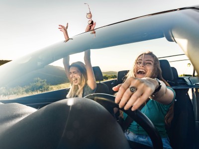 Zusatzfahrer-Versicherung: Zwei Frau im Cabrio entspannt unterwegs