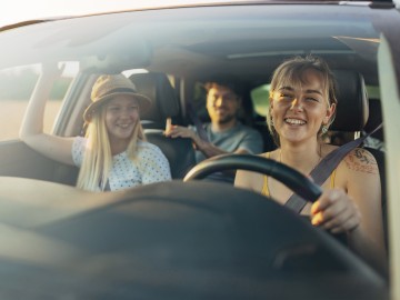 Kfz-Familienfahrer-Versicherung: Junge Leute sitzen vergn&uuml;gt in einem Auto