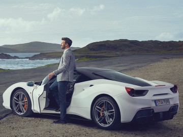 Luxusauto- & Sportwagen-Versicherung: Mann öffnet an einem weißen Sportwagen die Tür