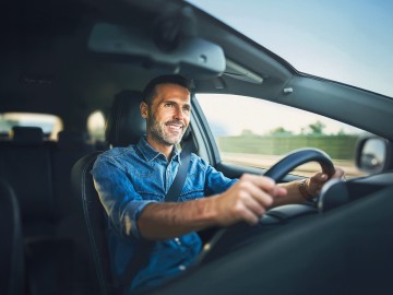 Kfz-Versicherung: Mann sitzt am Steuer eines Pkw