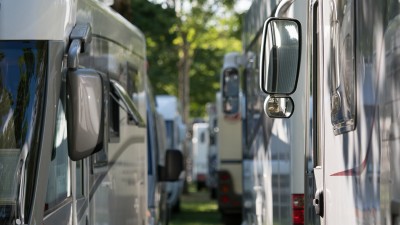Wohnmobile, eng parkend auf einem Parkplatz.