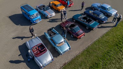 Oldtimer-Fahrzeuge stehen nebeneinander geparkt auf einem Platz