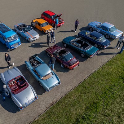 Oldtimer-Fahrzeuge stehen nebeneinander geparkt auf einem Platz