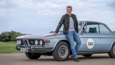 Oldtimer-Versicherung:  Mann lehnt an einem BMW-Oldtimer Klassiker
