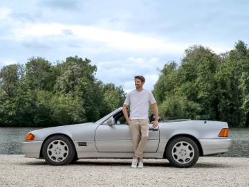 Youngtimer-Versicherung: Mann steht lässig vor seinem Mercedes-Youngtimer