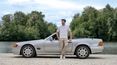 Youngtimer-Versicherung: Mann steht lässig vor seinem Mercedes-Youngtimer