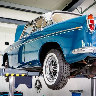 Oldtimer-Gutachten: Ein blauer Oldtimer auf der Hebebühne