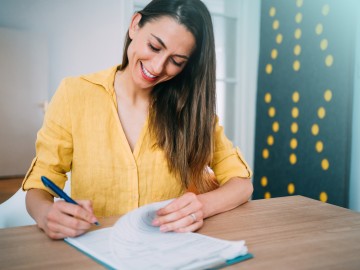 Frau unterschreibt Unterlagen