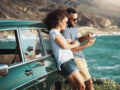 Mallorca-Police: Paar lehnt am Auto auf einer Klippe am Meer und schaut aufs Handy
