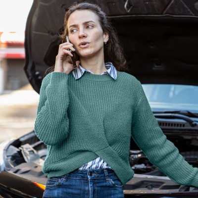 Frau mit Autopanne ruft telefonisch Hilfe
