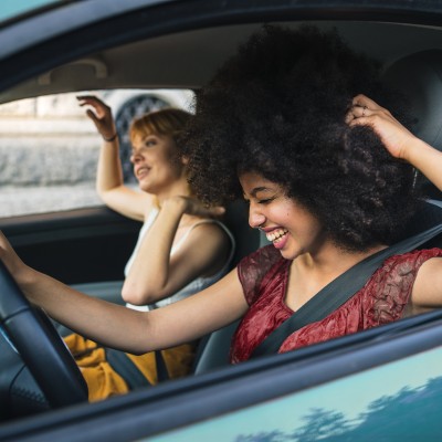 Zwei Frauen sitzt in einem Auto und lachen