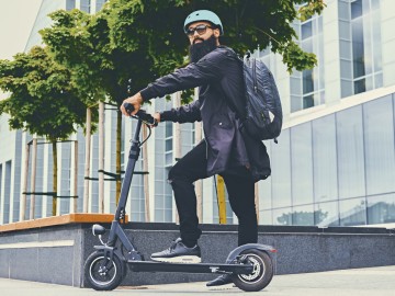 E-Scooter-Versicherung: Hipster mit E-Scooter