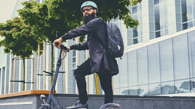 E-Scooter-Versicherung: Hipster mit E-Scooter