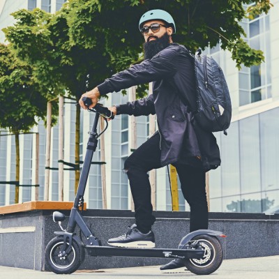 E-Scooter-Versicherung: Hipster mit E-Scooter