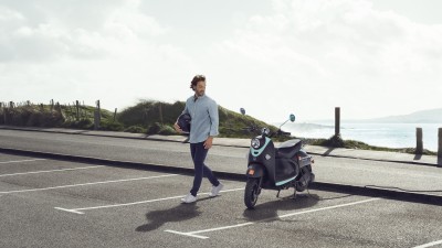 E-Roller- & E-Bike-Versicherung: Junger mann parkt seinen E-Motorroller