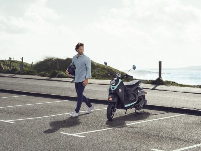 E-Roller- & E-Bike-Versicherung: Junger mann parkt seinen E-Motorroller