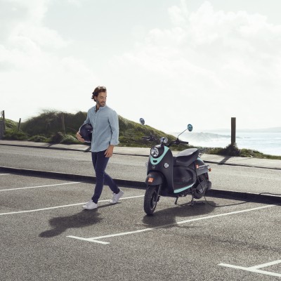 E-Roller- & E-Bike-Versicherung: Junger mann parkt seinen E-Motorroller