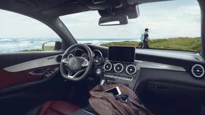 Hausratversicherung für Singles: Blick aus dem Auto auf Küstenlandschaft und Wanderer