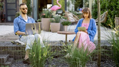 Ein Paar sitzt auf der Terrasse mit Garten.