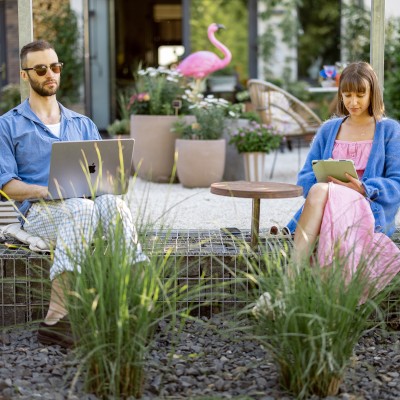 Ein Paar sitzt auf der Terrasse mit Garten.