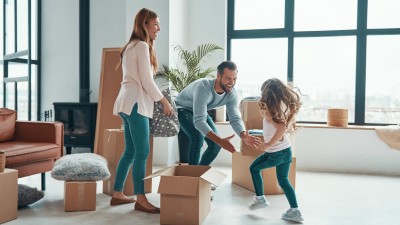 Eine Familie in einem Loft mit ein paar Möbeln und Umzugskartons