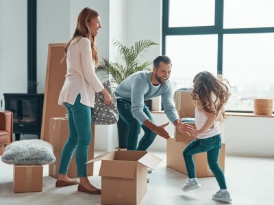 Eine Familie in einem Loft mit ein paar Möbeln und Umzugskartons