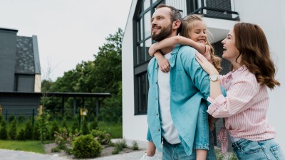 Junge Familie mit Kind stehen vor Ihrem neuen zu Hause