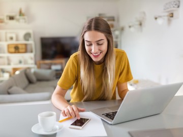 Eine Frau mit Laptop und Smartphone