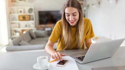 Eine Frau mit Laptop und Smartphone