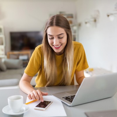 Eine Frau mit Laptop und Smartphone